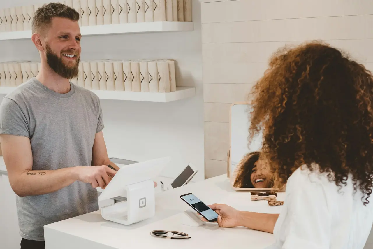 Cliente pagando con el móvil en la caja de un local